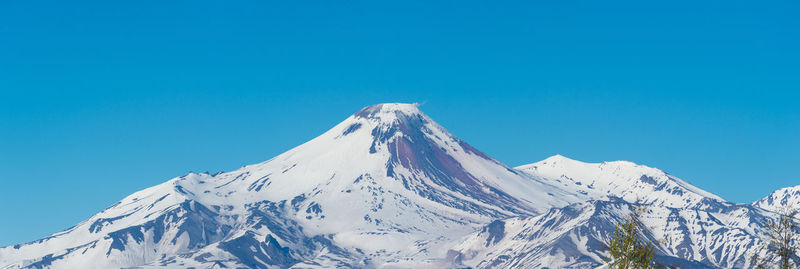 Scenic view of snowcapped mountains against clear blue sky