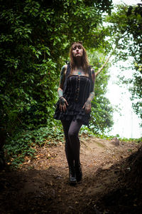 Portrait of young woman standing in forest