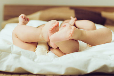 Twins lying down on bed at home