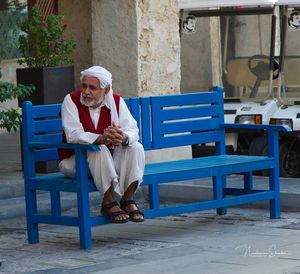 Full length of man sitting on table