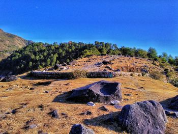 Scenic view of rocks against clear blue sky