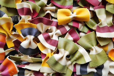 Close-up on a stack of uncooked multi colorful striped farfalles from italy.