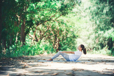 Full length of young woman practicing yoga at park