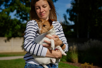 Portrait of woman with cat on field