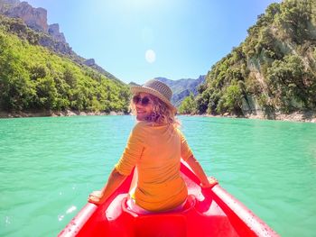 Portrait of young woman sitting in boat in lake