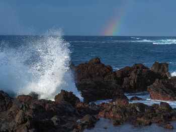 Atlantic waves crashing into volcanic rocks on the shore at puerto de la cruz tenerife