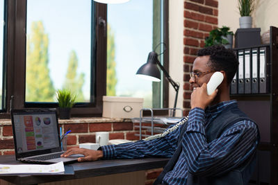 Businessman talking on phone while working at office