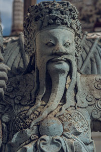 Close-up of buddha statue against building