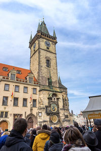 Rear view of tourists in front of astronomical clock tower