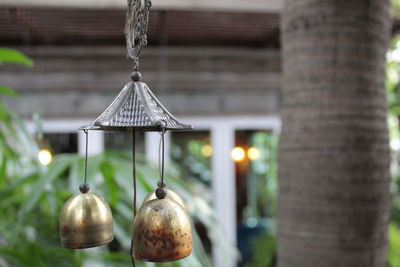 Close-up of illuminated lamp hanging against building