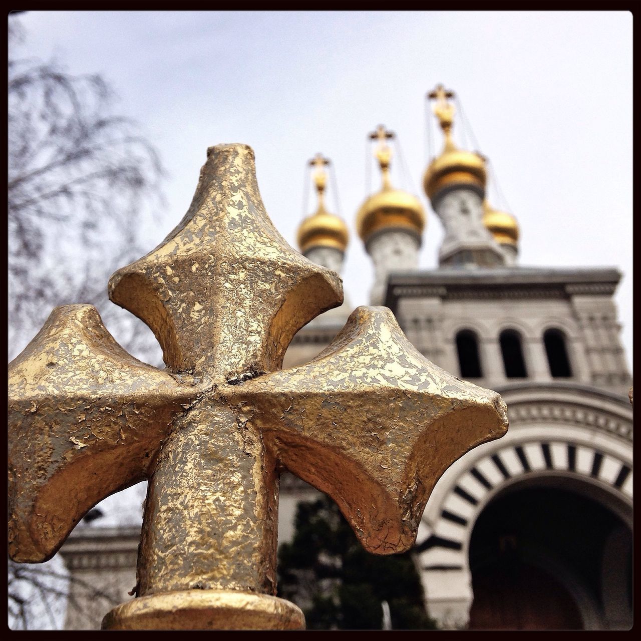 transfer print, close-up, auto post production filter, focus on foreground, pattern, design, religion, ornate, spirituality, day, low angle view, art and craft, built structure, no people, sky, indoors, in a row, sunlight, architecture