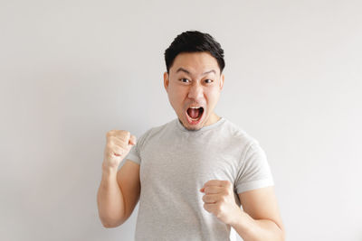 Portrait of young man standing against white background