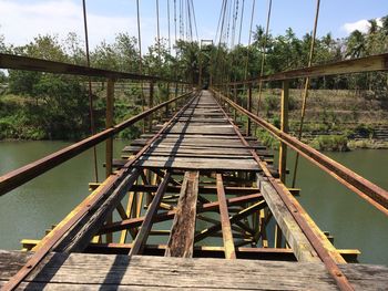 Footbridge over river against sky