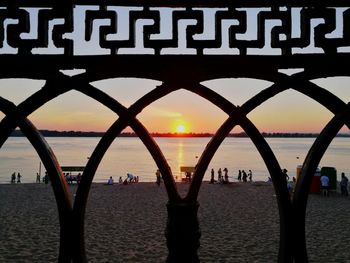 Silhouette of people on beach at sunset