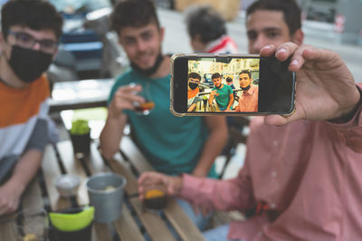 Man doing selfie with friends in restaurant
