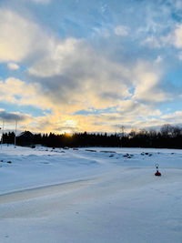 Scenic view of snow covered field against sky