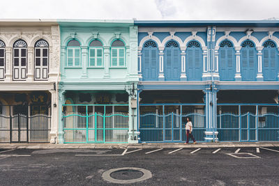 Rear view of woman standing against building