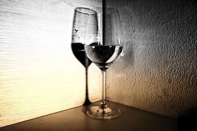 Close-up of wineglass on table against wall