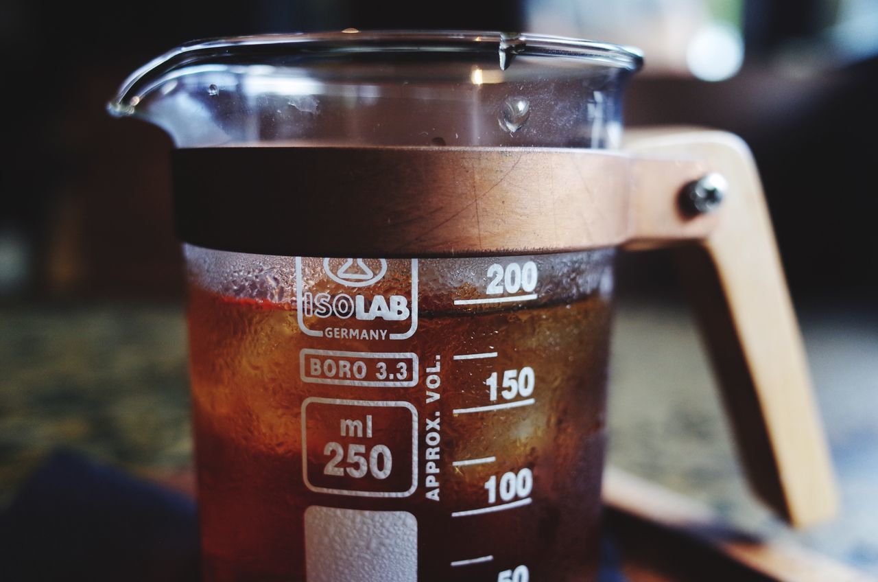 close-up, focus on foreground, indoors, text, western script, metal, communication, still life, selective focus, drink, food and drink, no people, container, refreshment, glass - material, table, metallic, number, day, technology