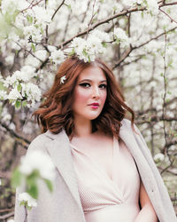 Beautiful girl in a dress walking in a blooming garden