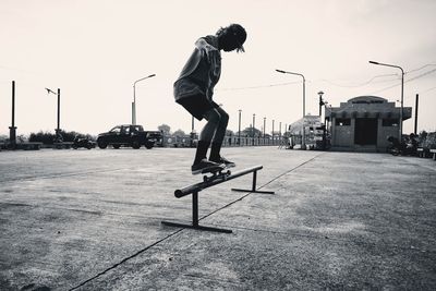 Full length of man jumping on skateboard against sky