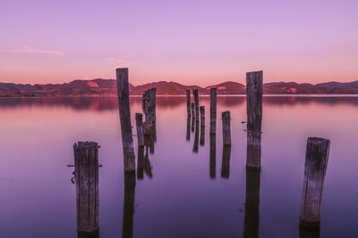 Pier over lake against sky during sunset