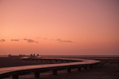 Scenic view of beach against clear sky during sunset