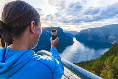 Woman taking picture of fjords