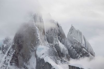 Panoramic view of snow covered mountains against sky