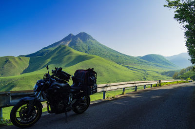 Motorcycle on road against mountain