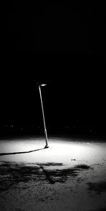 Street light on field against sky at night