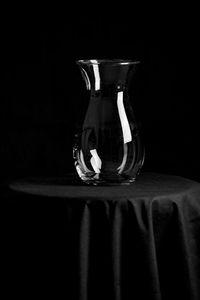 Close-up of empty glass on table against black background