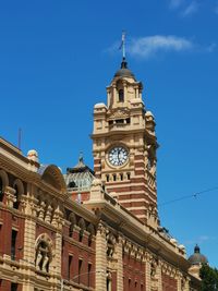 Low angle view of clock tower against blue sky