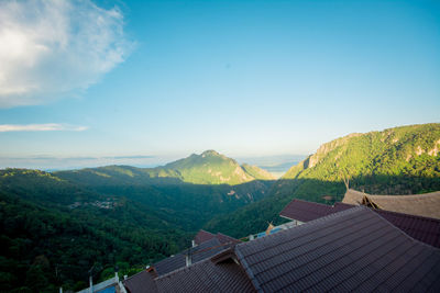 Scenic view of mountains and houses against sky