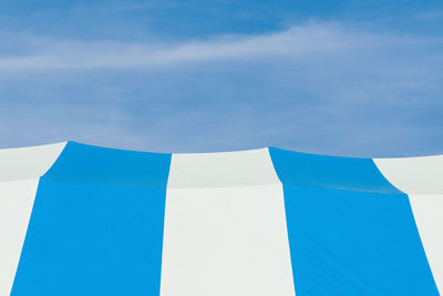 Low angle view of circus tent against blue sky