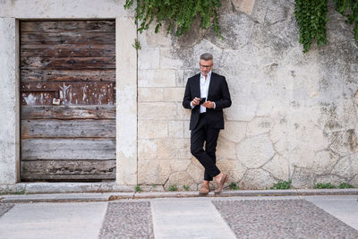 Businessman using mobile phone while standing outdoors