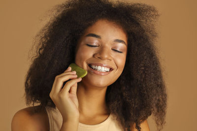 Portrait of young woman against wall