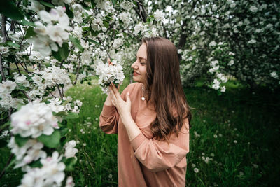 Beautiful young girl in the garden of blooming apple trees