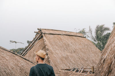 Rear view of man working against clear sky