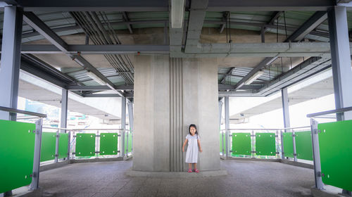 Full length of girl standing against column