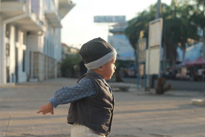 Rear view of cute baby  boy standing on street