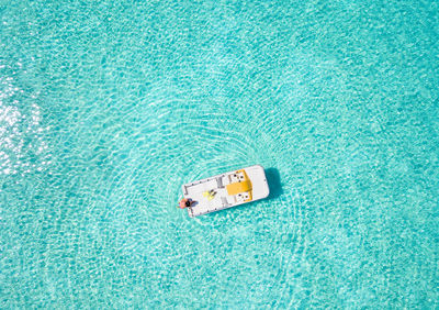 Directly above shot of woman in boat on sea during sunny day