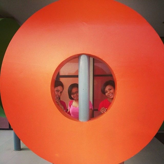 circle, indoors, geometric shape, red, built structure, architecture, wall - building feature, orange color, shape, close-up, no people, illuminated, round, creativity, art, mirror, communication, art and craft, day, wall