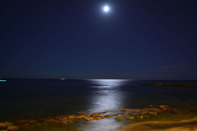 Scenic view of sea against clear sky at night