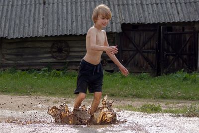 Side view of boy standing against wall