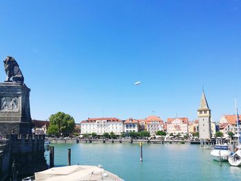 City at waterfront against blue sky