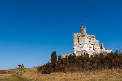 Low angle view of historical building against clear blue sky