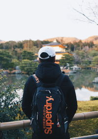 Rear view of man standing on field against sky