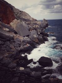 Rocks on sea shore against sky