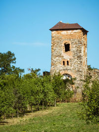 Old building on field against clear blue sky